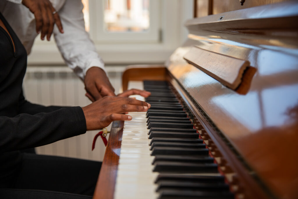 Gros plan des mains d'une fille jouant du piano avec un ami