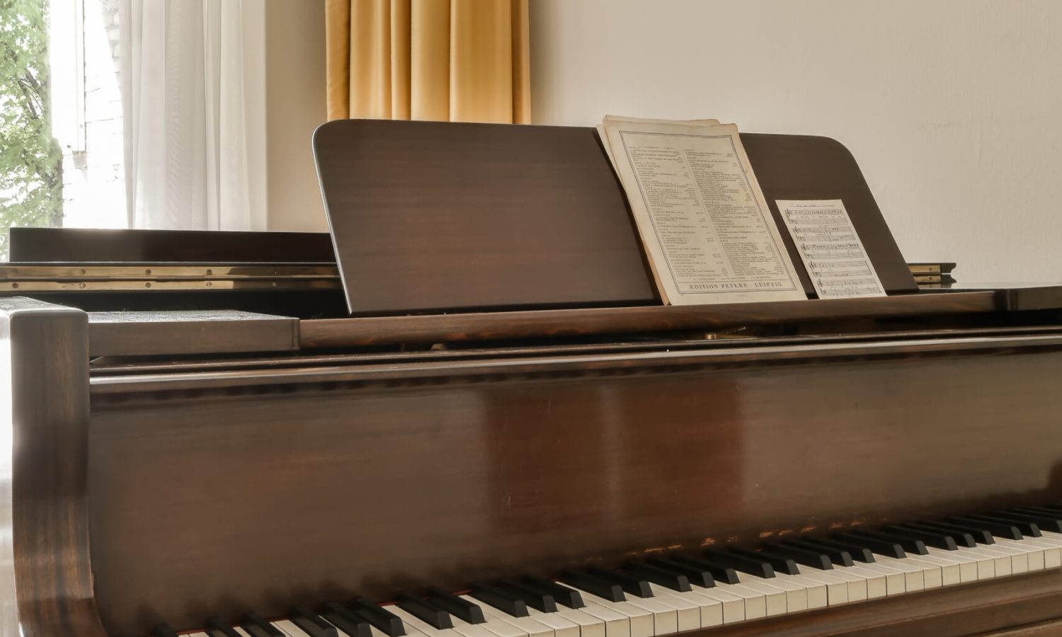 a piano in a room with a book on it un piano dans une pièce vide et eclairé
